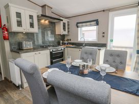 A kitchen with dining area and appliances at The Beaumont No 34 in New Quay