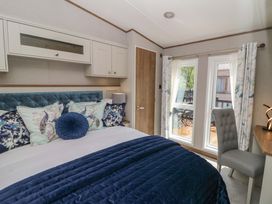 A bedroom with a bed and windows at The Beaumont No 34 in New Quay