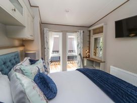 A bedroom with a bed and curtains at The Beaumont No 34 New Quay