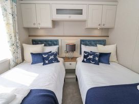 A bedroom with two beds and a bedside table at The Beaumont No 34 New Quay