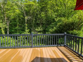 A deck with wooden flooring overlooking trees at The Beaumont No 34 in New Quay