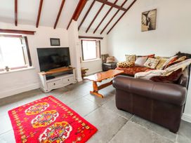 A living room with a television and a sofa at 2 Llainwen in Ty Croes