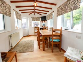 A dining room with a table and chairs at 2 Llainwen in Ty Croes
