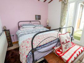 A bedroom with a bed and a bookshelf at 2 Llainwen in Ty Croes