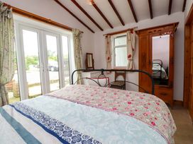 A bedroom with a bed and wardrobe at 2 Llainwen Ty Croes