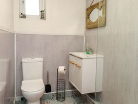 A bathroom with a white toilet and sink at 2 Llainwen in Ty Croes