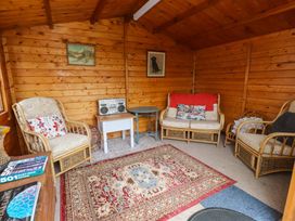 A snug with sofas, a table, and a boombox at 2 Llainwen Ty Croes