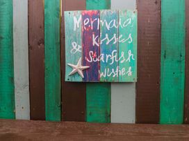 A wooden sign with a starfish on colorfully painted wood panels at 2 Llainwen Ty Croes