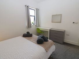 A bedroom with a bed, desk, and drawer unit at Harbour View in Whitehaven