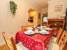A dining room with a table set for a meal at Fairways House in Weymouth