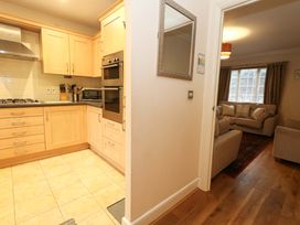 A kitchen with cabinets and appliances at Fairways House in Weymouth