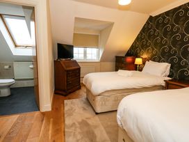 A bedroom with two beds and a television at Fairways House in Weymouth