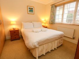 A bedroom with a bed and bedside table at Fairways House in Weymouth