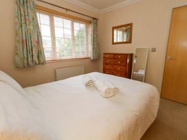 A bedroom with a bed and dresser at Fairways House in Weymouth