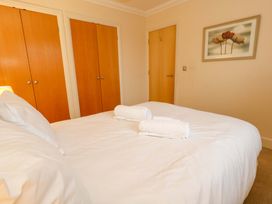 A bedroom with a bed and towels at Fairways House Weymouth