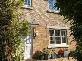 An outdoor view of a house with a door and flower pots at Fairways House in Weymouth