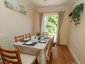 A dining room with a table set for meals at Fairways House in Weymouth