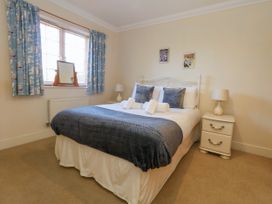 A bedroom with a bed and nightstand at Fairways House Weymouth
