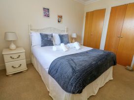 A bedroom with a bed and nightstand at Fairways House in Weymouth