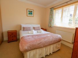 A bedroom with a bed and bedside tables at Fairways House in Weymouth