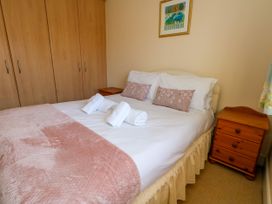 A bedroom with a bed and wardrobe at Fairways House in Weymouth