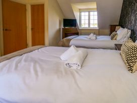 A bedroom with two beds and a television at Fairways House in Weymouth