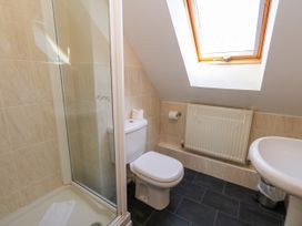 A bathroom with a shower, toilet, and sink at Fairways House in Weymouth
