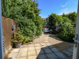A garden with plants, a table, and a chair at Fairways House in Weymouth