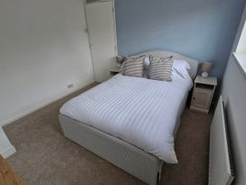 A bedroom with a bed and bedside tables at 13 Seafield Road