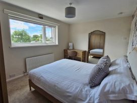 A bedroom with a bed, desk, and mirror at 13 Seafield Road