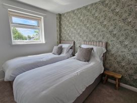 A bedroom with two beds and a window at 13 Seafield Road