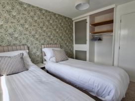 A bedroom with two beds and a wardrobe at 13 Seafield Road 