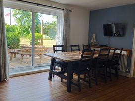 A dining room with a table and chairs visible through a sliding door at The Warren in Seahouses