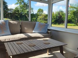 A conservatory with a sofa and coffee table at The Warren in Seahouses