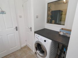 A laundry room with a washing machine and countertop at Bari House in Seahouses