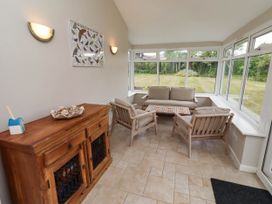 A conservatory with seating and a cabinet at Bari House in Seahouses