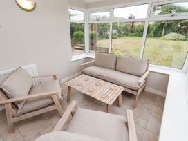 A conservatory with seating and a view of the garden at Bari House in Seahouses