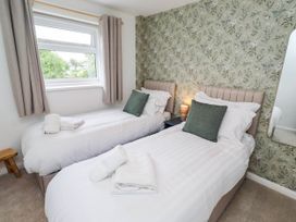 A bedroom with two beds and a window at Bari House in Seahouses