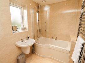 A bathroom with a bathtub and sink at Bari House in Seahouses