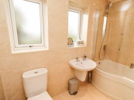 A bathroom with a sink, shower, bath, and toilet at Bari House in Seahouses
