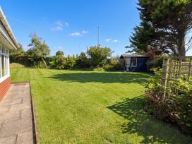 A garden with grass and a shed at Bari House Seahouses
