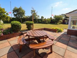 A garden with a wooden table and benches at Bari House in Seahouses