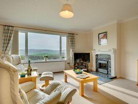 A living room with an armchair, coffee table, and fireplace at The Granary in Alnwick