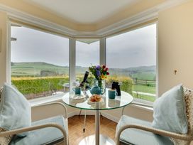 A dining area with a table, chairs, and view at The Granary in Alnwick