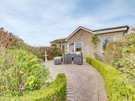 A garden with a house and patio seating area at The Granary in Alnwick