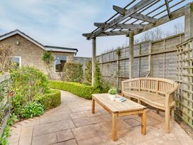 A garden with a stone pathway and wooden bench at The Granary in Alnwick
