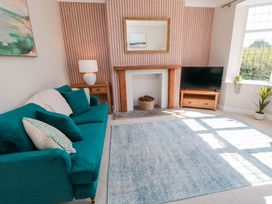 A living room with a sofa and television at 60 Muston Road in Filey