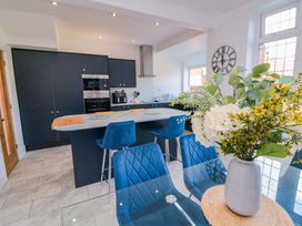 A kitchen with black cabinets and island countertop at 60 Muston Road in Filey