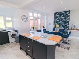 A kitchen with a washing machine and dining area at 60 Muston Road in Filey