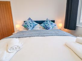 A bedroom with a bed and decorative pillows at 60 Muston Road in Filey